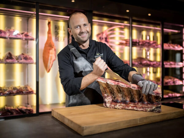 Metzger schneidet das Fleisch mit einem Messer